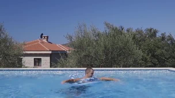 Mann vergnügt sich im Urlaub im Schwimmbad — Stockvideo