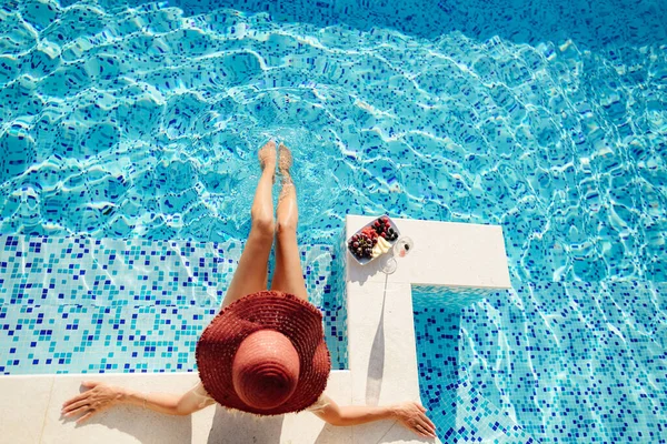 Vrouw ontspannen in het zwembad en drinkt champagne — Stockfoto