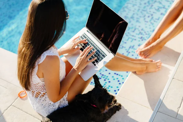 women using laptop work outdoors with cute dog