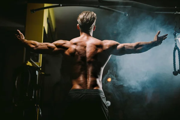Muskulöser Mann posiert im Fitnessstudio Hintergrund — Stockfoto