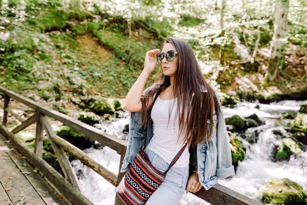 Mujer relajarse en el bosque de otoño con fondo de cascada — Foto de Stock