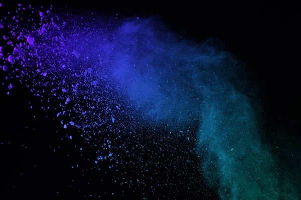 Blue powder explosion on black background. Blue dust explode on dark background. Paint Holi. Explosion of colored powder on black background