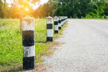 Kilometre taşları - yeşil çim yol kenarı, ağaçlar yol kenarı arka plan ile siyah ve beyaz kilometre taşları. bir sonraki adım için kavram. Bir sonraki istasyon. Düzey yukarı.