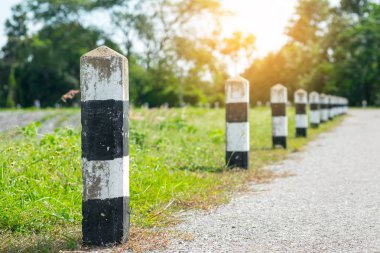 Kilometre taşları - yeşil çim yol kenarı, ağaçlar yol kenarı arka plan ile siyah ve beyaz kilometre taşları. bir sonraki adım için kavram. Bir sonraki istasyon. Düzey yukarı.