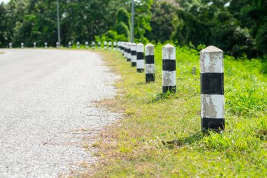 Kilometre taşları - yeşil çim yol kenarı, ağaçlar yol kenarı arka plan ile siyah ve beyaz kilometre taşları. bir sonraki adım için kavram. Bir sonraki istasyon. Düzey yukarı.