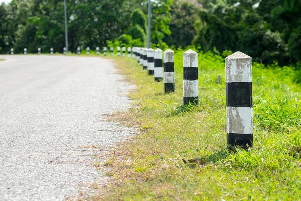 Kilometre taşları - yeşil çim yol kenarı, ağaçlar yol kenarı arka plan ile siyah ve beyaz kilometre taşları. bir sonraki adım için kavram. Bir sonraki istasyon. Düzey yukarı.