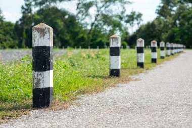 Kilometre taşları - yeşil çim yol kenarı, ağaçlar yol kenarı arka plan ile siyah ve beyaz kilometre taşları. bir sonraki adım için kavram. Bir sonraki istasyon. Düzey yukarı.