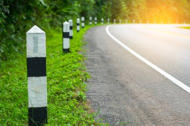 Siyah ve beyaz kilometre taşları yeşil çim yol kenarı, ağaçlar yol kenarı arka plan ile. bir sonraki adım için kavram. Bir sonraki istasyon.