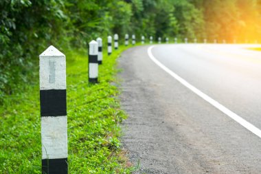 Siyah ve beyaz kilometre taşları yeşil çim yol kenarı, ağaçlar yol kenarı arka plan ile. bir sonraki adım için kavram. Bir sonraki istasyon.