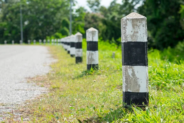 Kilometre taşları - yeşil çim yol kenarı, ağaçlar yol kenarı arka plan ile siyah ve beyaz kilometre taşları. bir sonraki adım için kavram. Bir sonraki istasyon. Düzey yukarı.