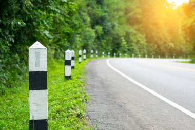 Siyah ve beyaz kilometre taşları yeşil çim yol kenarı, ağaçlar yol kenarı arka plan ile. bir sonraki adım için kavram. Bir sonraki istasyon.