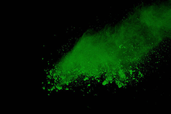 Green powder explosion on black background. Colored cloud. Color dust explode. Paint Holi.