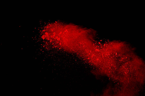 Abstract of red powder explosion on black background. Red powder splatted isolate. Colored cloud. Colored dust explode. Paint Holi.