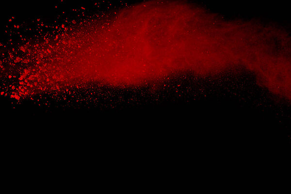 Explosion of red powder on black background. Abstract of colored dust splatted.