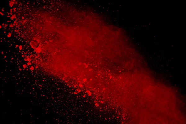 Abstract of red powder explosion on black background. Red powder splatted isolate. Colored cloud. Colored dust explode. Paint Holi.