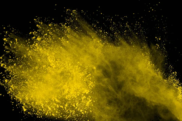 Abstract of yellow powder explosion on black background. Yellow powder splatted isolate. Colored cloud. Colored dust explode. Paint Holi.