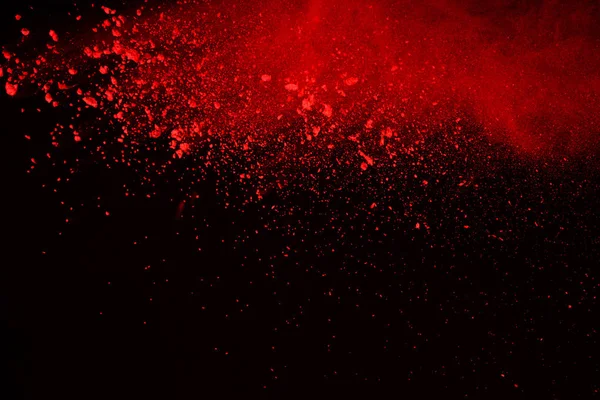 Abstract of red powder explosion on black background. Red powder splatted isolate. Colored cloud. Colored dust explode. Paint Holi.