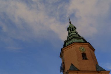 Uçan kuşlarla dolu tarihi kule silueti yumuşak bir akşam gökyüzüne karşı.