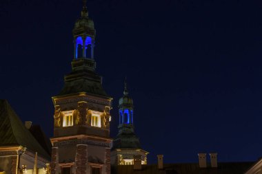 Derin bir gece gökyüzüne karşı güzelce aydınlatılmış kuleleri olan görkemli bir saray..