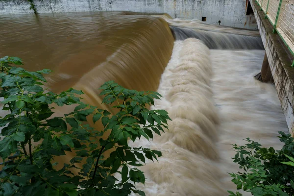 Dinamik kentsel ortamda insan yapımı baraj üzerinde hızlı akan su çağlayanı.
