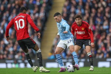 Manchester City 'den Phil Foden, Manchester City ile Manchester United arasındaki Premier League maçında Manchester United' ın 3 Mart 202 'de Etihad Stadyumu' nda attığı baskıyla topu kontrol ediyor.
