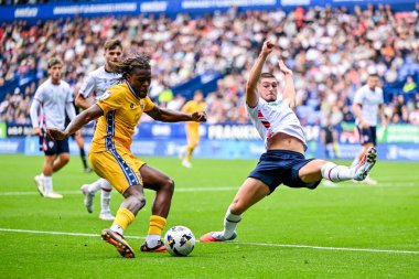 AFC Wimbledon 'dan Nathan Asiimwe, Bolton Wanderers takımının oyuncusu Xavier Simons' la, Bolton Wanderers 'ın AFC Wimbledon' a karşı oynadığı maçta, Bolton Wanderers 'ın maçını geçmeye çalışıyor.