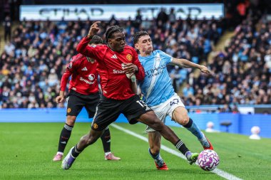 Manchester United 'dan Patrick Dorgu ve Manchester City Premier League maçında Manchester City ile Manchester United arasında 14 Eylül 2025' te Etihad Stadyumu 'nda oynanan maçta top için mücadele eden Phil Foden.