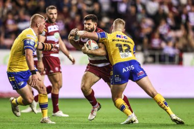 Abbas Miski of Wigan Warriors is tackled by James McDonnell of Leeds Rhinos during the Betfred Super League round 27 match Wigan Warriors vs Leeds Rhinos at The Brick Community Stadium, Wigan, United Kingdom, 19th September 2025