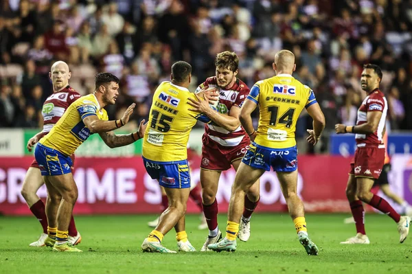 Ethan Havard of Wigan Warriors is tackled by Sam Lisone of Leeds Rhinos during the Betfred Super League round 27 match Wigan Warriors vs Leeds Rhinos at The Brick Community Stadium, Wigan, United Kingdom, 19th September 2025 