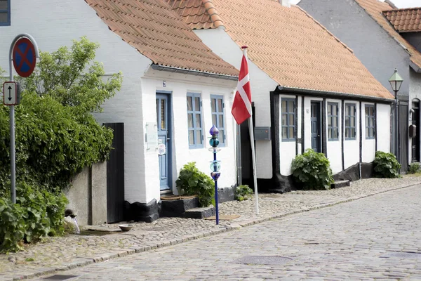 Old Houses in Ebeltoft in Denmark, with the Danish Flag and old street lamp