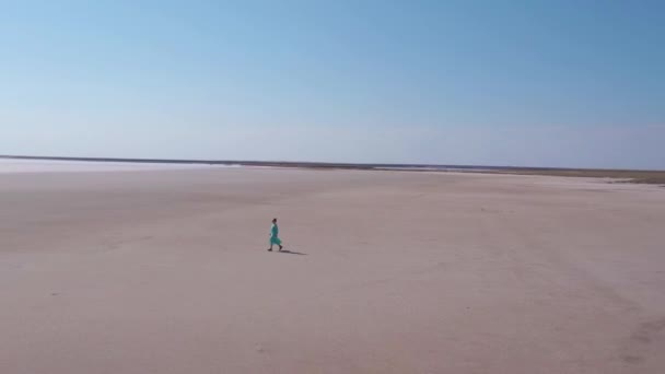 Flyga runt vacker kvinna i lång blå klänning promenader ensam i salt dessert. — Stockvideo