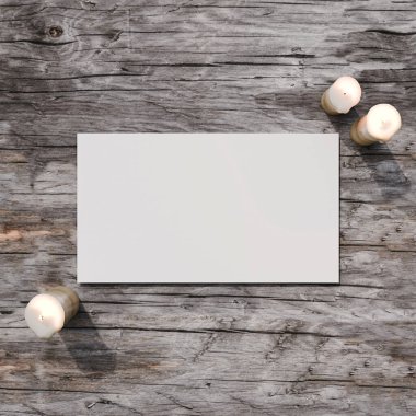 Kırsal ahşap üzerinde boş bir beyaz kartın yer aldığı doğal temalı bir maket. Yanında mumlar, düğün davetiyeleri veya kırsal tasarım sunumları için mükemmel..