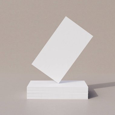 Dağıtılmış kartların üzerinde yüzen beyaz bir kartın basit ve temiz bir tasarımı, iş veya sunum modelleri için minimalist bir kompozisyon oluşturur.