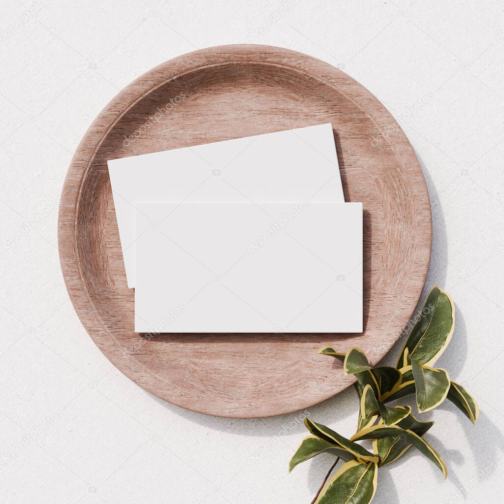 Business cards arranged on a round wooden plate with green accents, ideal for earthy or rustic branding.