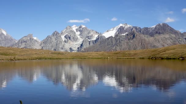 Picos nevados del Cáucaso que se reflejan en el lago — Vídeos de Stock