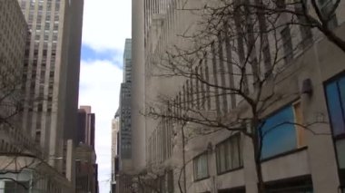 Bulutlu gökyüzü ve gökdelenler ile New York sokaklarından düşük açılı bir görünüm.