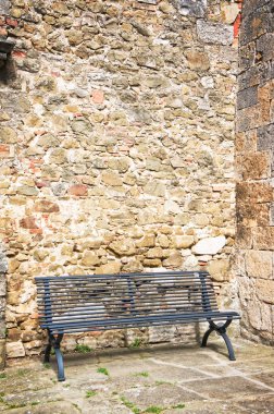 Taş bir duvarda boş bir bank 