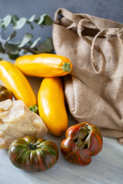 Pomodori Ricurvi Zucchine Gialle Parmigiano Tela Fondo Grigio Foglie Eucalipto — Foto Stock