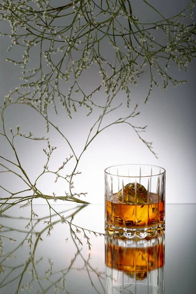 Vaso Brandy Con Cristal Sobre Mesa Con Reflejo Flores Florecientes — Foto de Stock