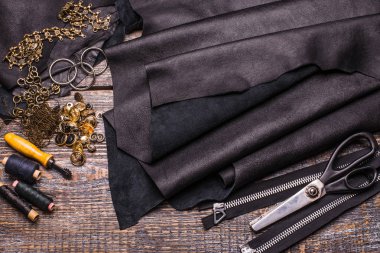 Deri dikiş deri şeyler için dikiş için bir küme yaprak: konu, makas, fermuar-bağlantı elemanları, metal perçin, ahşap arka plan düğmeleri