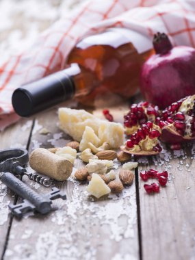 Beyaz bir eski vintage arka planda bir tekstil havlu ile gül şarabı, granat, peynir, mantar, tirbuşon, beyaz ekmek çeşitli bir dizi hizmet