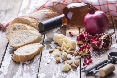 Beyaz bir eski vintage arka planda bir tekstil havlu ile gül şarabı, granat, peynir, mantar, tirbuşon, beyaz ekmek çeşitli bir dizi hizmet