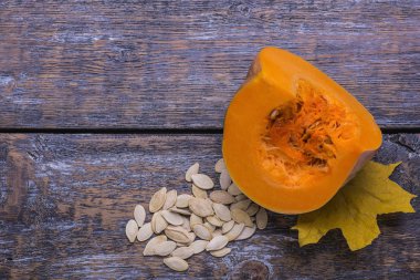 Barış tohum ve sarı yaprak ahşap arka plan üzerinde olgunlaşmış doğal kabak.