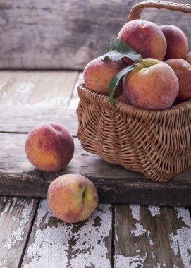 Taze olgunlaşmış doğal meyve ile büyük backet üzerinde eski bir ahşap masa şeftali, metin altında yer.