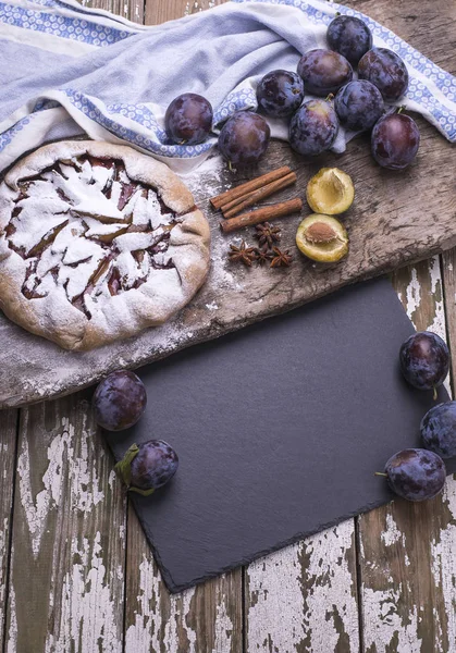 Siyah taş tarifi için yönetim kurulu ve fırından yeni çıkmış bir ahşap tahta üzerinde organik erik ile doğal ev yapımı kurabiye masa. Üstten görünüm.