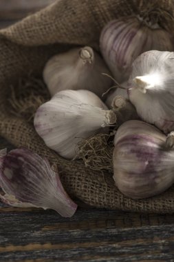 Doğal Organik taze sarımsak metin için yer bir ahşap rustik zemin üzerine bir çantada. Yakın çekim.