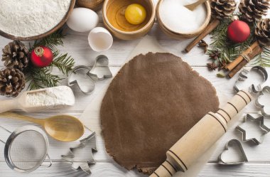 Ahşap beyaz bir arka plan üzerinde tatil çerezleri pişirme için taze malzemelerden doğal ev yapımı haddeleme hamur. Düz yatıyordu