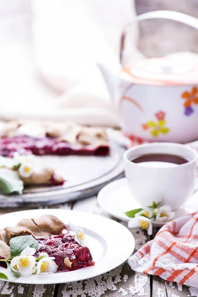 Summer freshly homemade baked berry cake with cup of black tea and teepot on a wooden table. — Stock Photo, Image