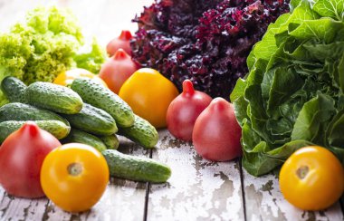 Vegan salata pişirme için doğal taze madde - domates, salatalık, ahşap bir arka plan üzerinde marul. Kopyalama alanı.