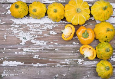 Ahşap bir arka plan üzerinde organik olgun kabak ve paprica köşe çerçevesi.